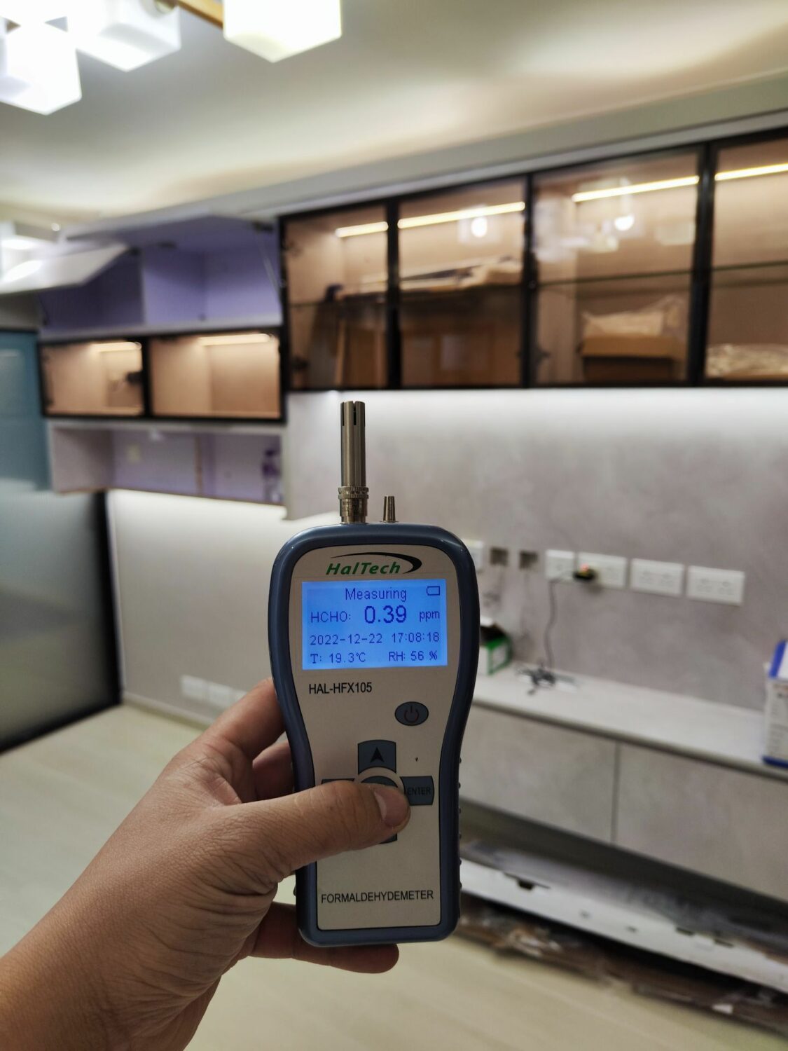 除甲醛服務後，一個人在房間裡拿著一個甲醛測量儀器。